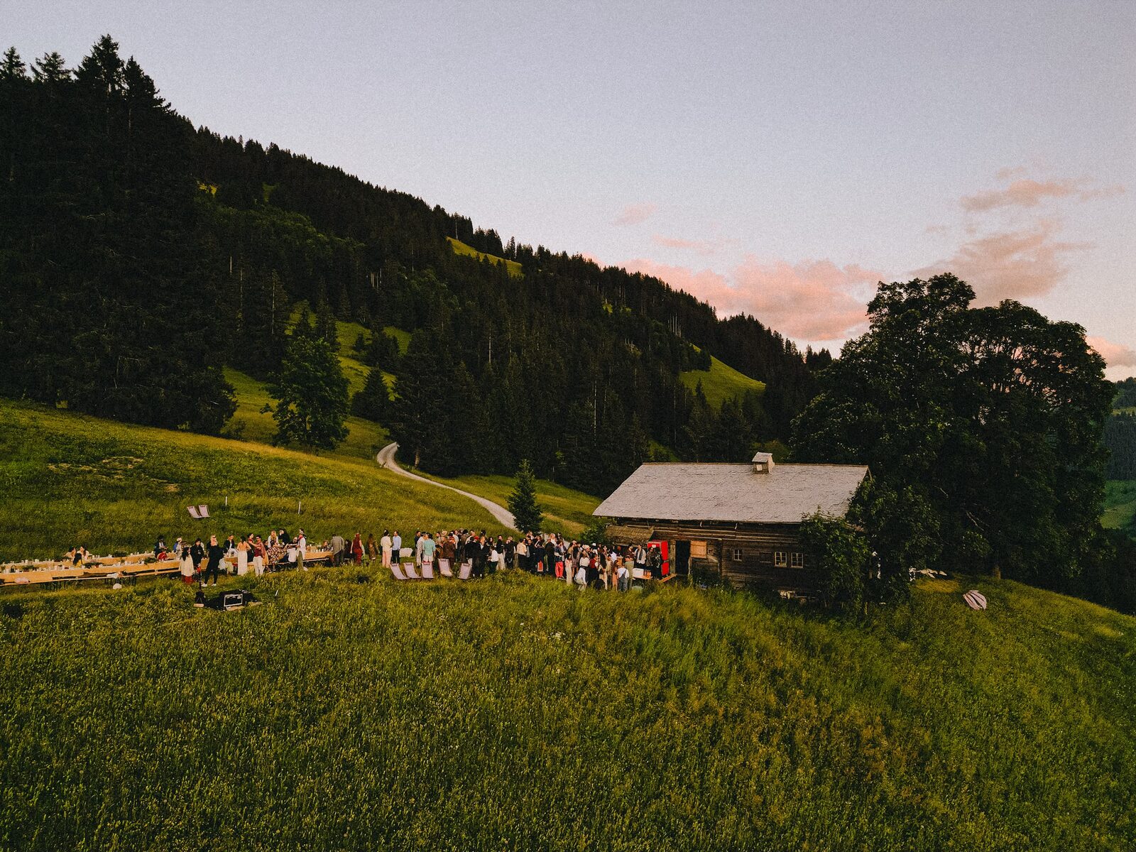 Guests outside the wooden chalet at dusk